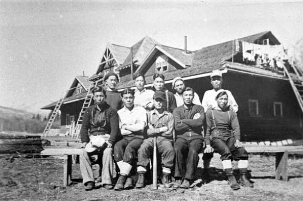 Japanese Canadian men sitting in front of former railroad station at Lucerne, 1940-1949