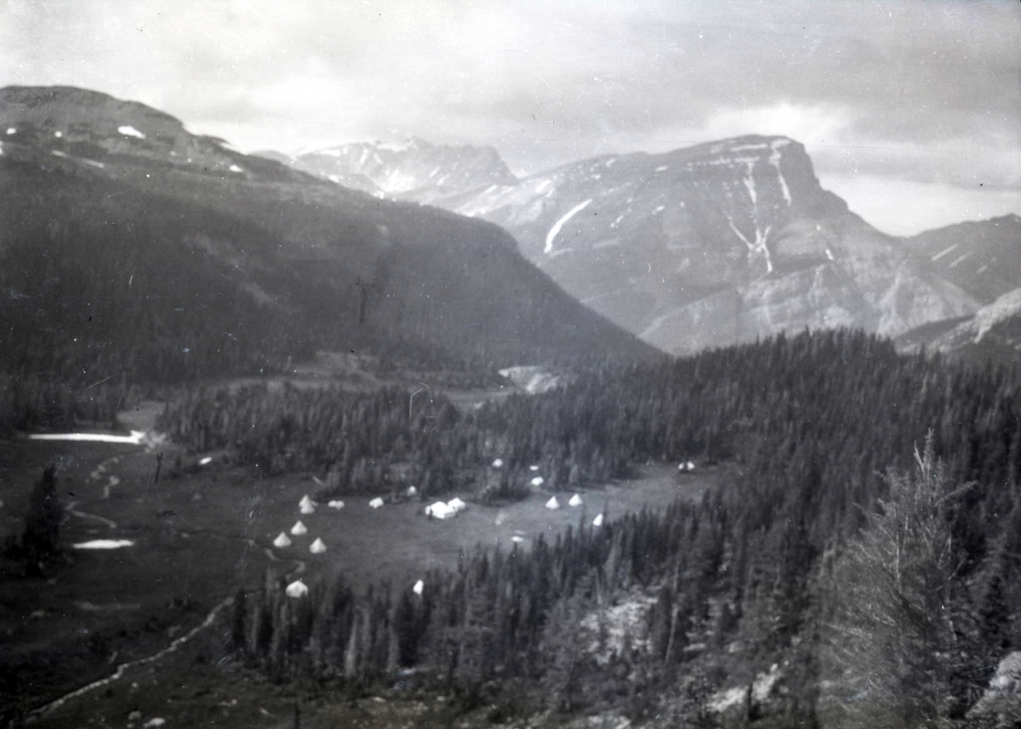 A group of white tents in a clearing, photographed from above. Andrew J. Gilmour Collection AJG.B4A8.007