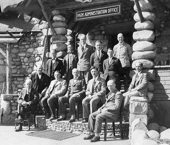 Jasper National Park employees pictured in front of the Park Administration Building in 1931. Group includes (sitting): E.A. Sullivan (instrument man), J.B. Snape (res. engineer), Col. S. Maynard Rogers (superintendent), H.G. Carlton (accountant), R.W. Langford (superintendent, warden). Standing: C.E. Burrows (steno), H.E. Sullivan (steno), W.R. Evans (foreman), J.R. Heckley (cashier), A.J Dube (timekeeper) W.Booth (clerk), H.S. Davis (game warden) and A.L. Withers (clerk). JYMA PA 18-110.